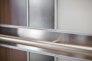 FSRT694 Интерьер лифта Levele-101 с индивидуальной компоновкой панелей; панели из стекла vivichrome chromis с белой прослойкой и отделкой opalex, плавленый графит с льняной отделкой, нержавеющая сталь с матовой отделкой, индивидуальный шпон; Круглый поруч Forms-surfaces 