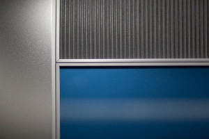 FSRT718 Стеновая система Levele с индивидуальной компоновкой панелей; основные панели из клееного алюминия с естественной патиной и рисунком травы; центральные акцентные панели из стекла vivichrome chromis с прослойкой индивидуального цвета и стандартной